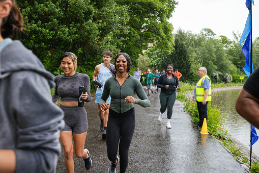 A group of cheerful run participants taking part in a fun run in Leazes Park in Newcastle upon Tyne, North East England. They are running together as a community group and it is raining. The race is open to people of all ages and abilities and is also dog friendly. \n\nThese files have similar videos/images available.