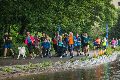 A wide shot of a group of run participants taking part in a fun run in Leazes Park in Newcastle upon Tyne, North East England. They are setting off together as a community group and it is raining. The race is open to people of all ages and abilities and is also dog friendly. 

These files have similar videos/images available.