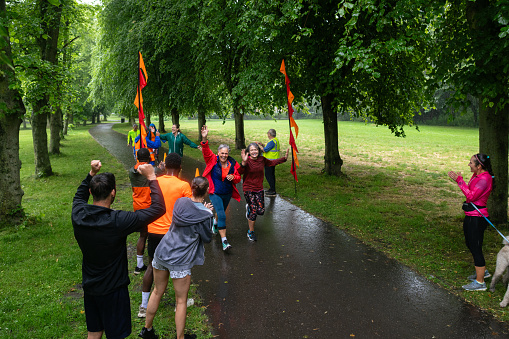 A group of run participants taking part in a fun run in Leazes Park in Newcastle upon Tyne, North East England. Some of them are crossing the finish line as supporters stand at the finish line and clap for them. The race is open to people of all ages and abilities and is also dog friendly.\n\nThese files have similar videos/images available.