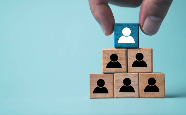 istock Hand stacking white human icon on the top of black people icon for human development and successful promotion position in organization of company concept. 1704207563