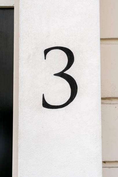 istock Number three door number hand painted in black on white wall 1704208125