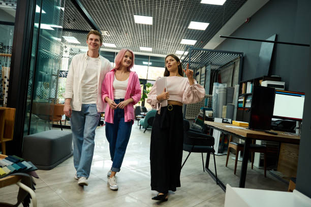 istock Three people, two women and a man, walk through a spacious room 1704208707