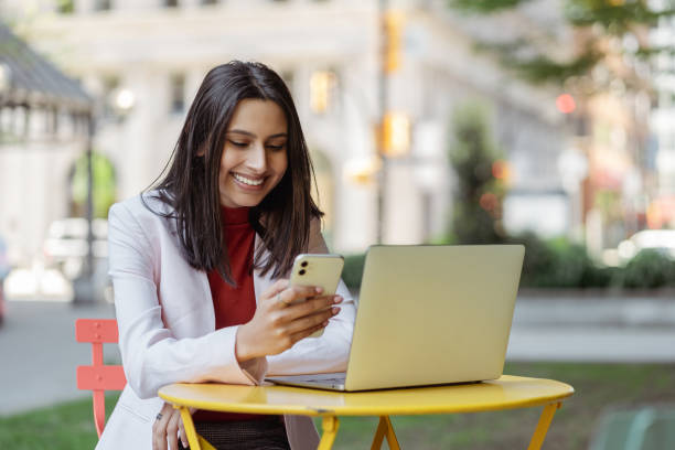 istock Beautiful smiling Indian woman holding mobile phone reading text message 1704210314
