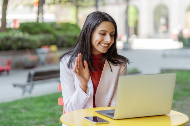 istock Smiling Indian woman greeting at laptop computer video call 1704210396
