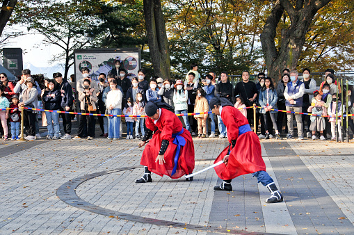 Seoul, South Korea - October 23, 2022: Traditional Korean Kingdom Soldier Warriors fighting performance among group of tourists in Namsan Mountain