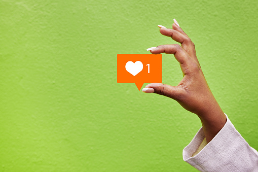 Hand, heart and like emoji with a person on green background mockup in studio for social media. Banner space, icon and post with an adult holding a logo closeup for communication or networking