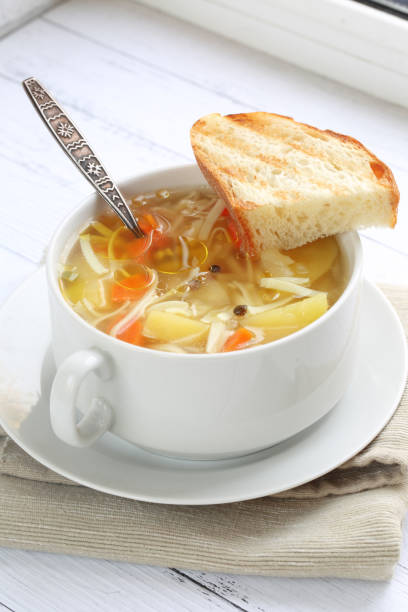 istock Soup with noodles and bread on white background 1704251038