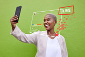 Phone selfie, live streaming video and black woman with heart emojis, media icons and social network feedback. Cellphone recording, content creator and influencer broadcast on green background wall