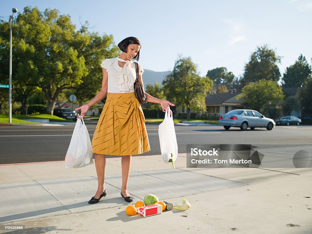 Недоволен женщина бросает продукты на тротуар - Стоковые фото Сумка - ёмкость для переноски роялти-фри