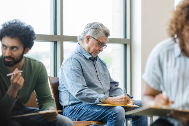 istock Diverse group of patients fill out forms while waiting to be seen at the clinic 1704271206