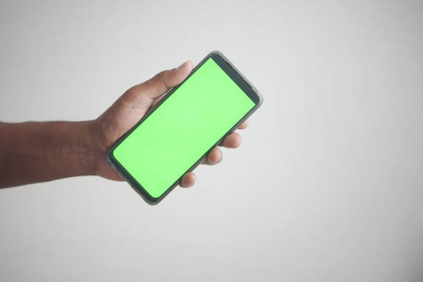 istock Close up of young man hand using smart phone with green screen 1704293628