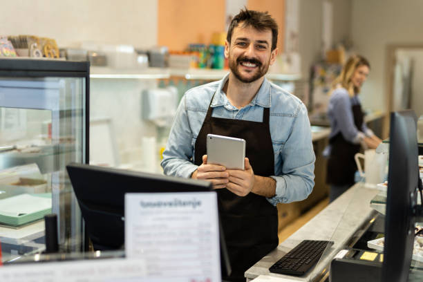 istock Smiling young  male baker at the checkout counter. 1704308596