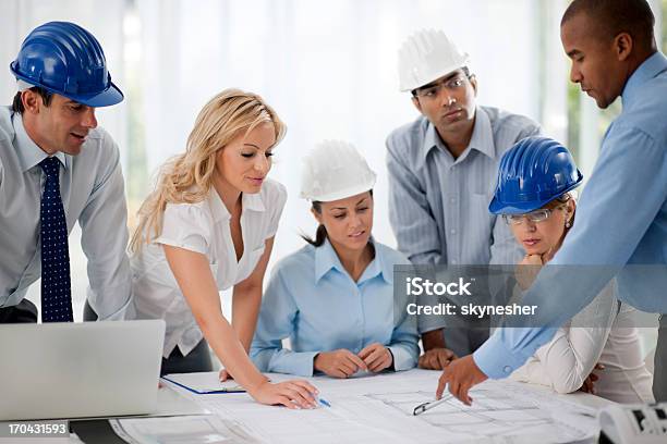 Grupo De Arquitectos Trabajando En Un Proyecto Foto de stock y más banco de imágenes de Ingeniero - Ingeniero, Documento, Grupo grande de personas