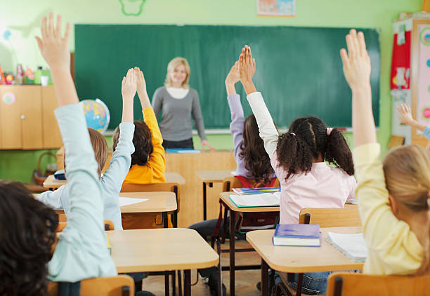 crianças com as mãos levantadas em sala de aula - blackboard professor expertise child - fotografias e filmes do acervo