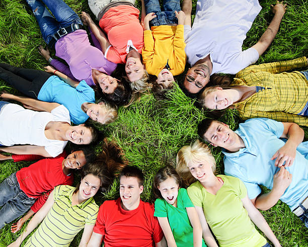 istock Large group of people lying on the grass in circle. 170431867