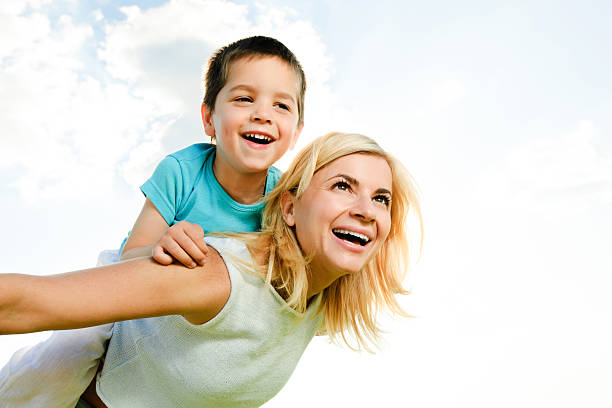istock Beautiful mother giving her son a piggyback ride 170431875