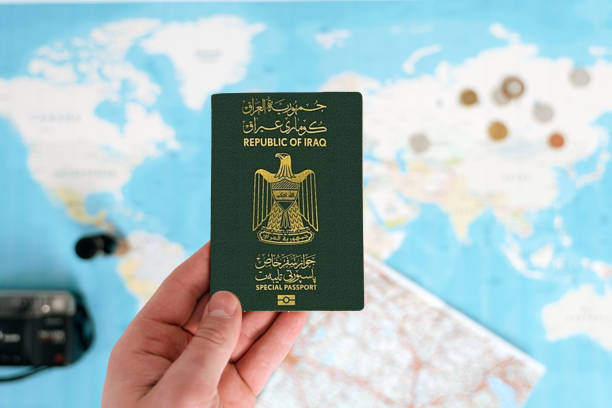 istock Iraqi passport holding in hand with maps 1704369288