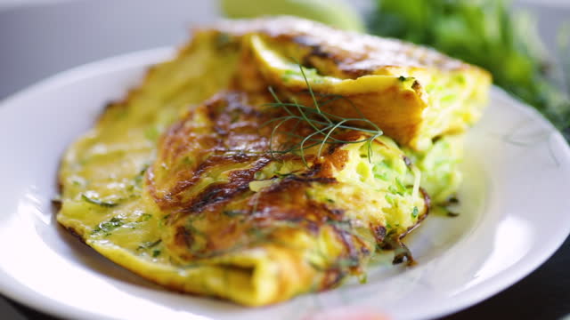 Fried omelet with zucchini, on a wooden table.