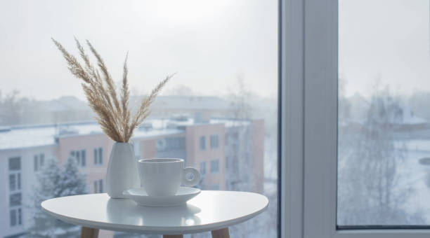 istock cup of coffee on white table by window on winter 1704404106