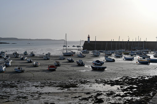 Erquy, Brittany, France, September 5, 2023 - Port and lighthouse at dusk and low tide of Erquy, Côtes-d'Armor department, Brittany.