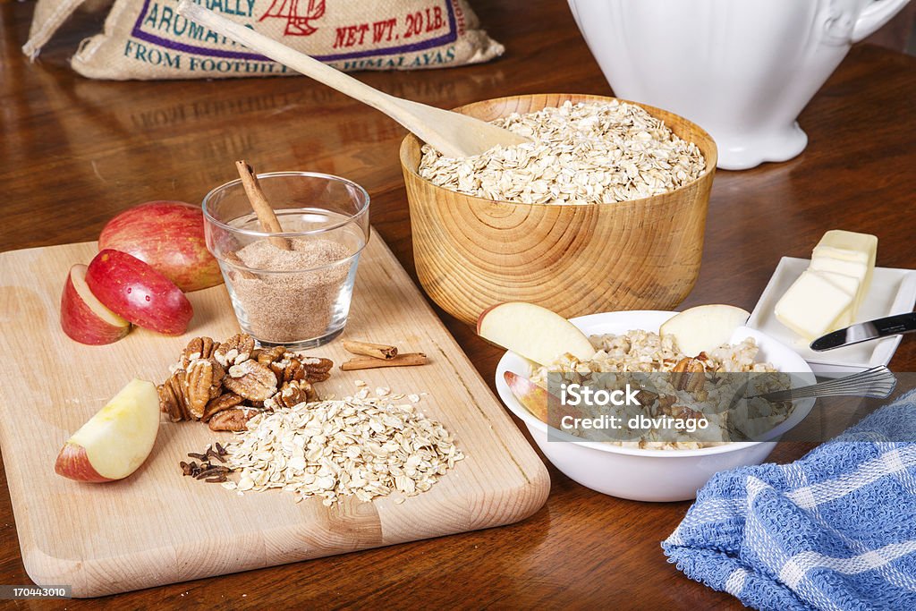 Preparing Oatmeal with Nuts and Spices Ingredients on a table to prepare a hot bowl of oatmeal Apple - Fruit Stock Photo