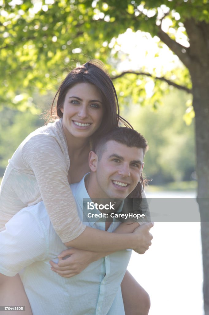 happy couple happy young woman getting a piggy back from boyfriend 20-29 Years Stock Photo