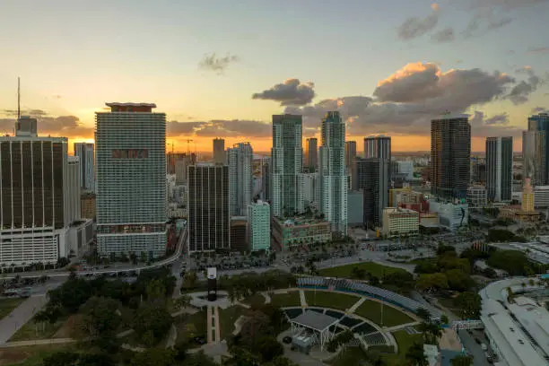 Aerial view of downtown district of of Miami Brickell in Florida, USA at sunset. High skyscraper buildings and street with cars and Metrorail traffic in modern american midtown.
