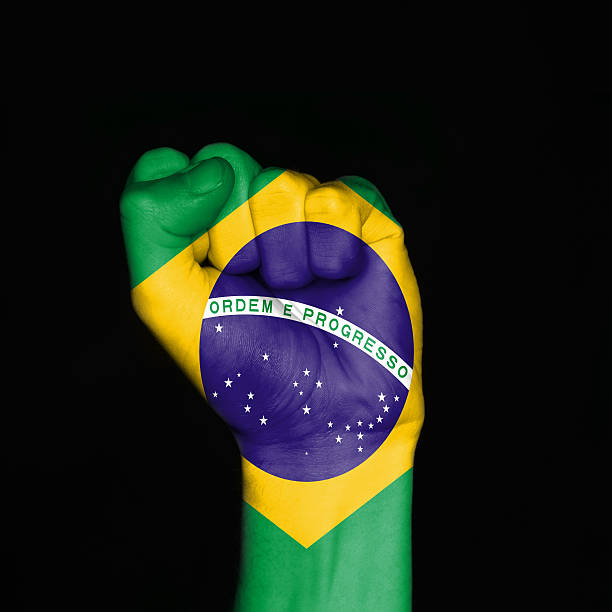 Strenght of Brazil Brazil flag painted on fist over black background. Symbol of strenght. independence stock pictures, royalty-free photos & images