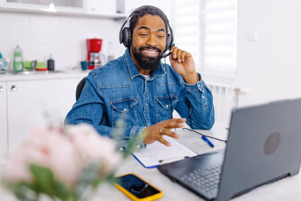 istock African American man wearing a headset and cheerfully talking to a customer 1704474522