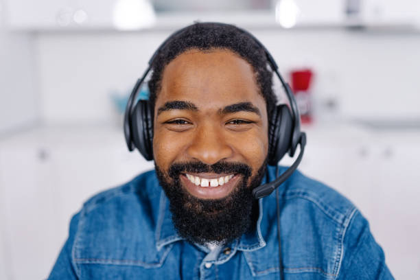 istock African American man with a cheerful smile, wearing a wireless headset 1704475583