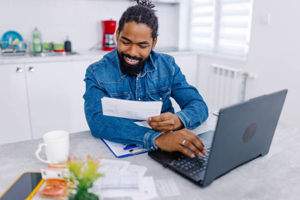 istock African American man cheerfully sorting his financial bills at home 1704475609