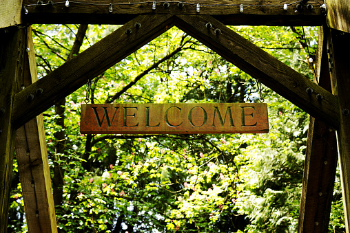 Welcome wooden sign on entrance gate in the woods