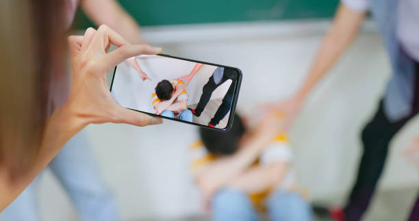 school bullying concept school bullying concept - asian woman is recording the video about classmates are criticizing and blaming the depressed male student exclusion group of people separation fish out of water stock pictures, royalty-free photos & images