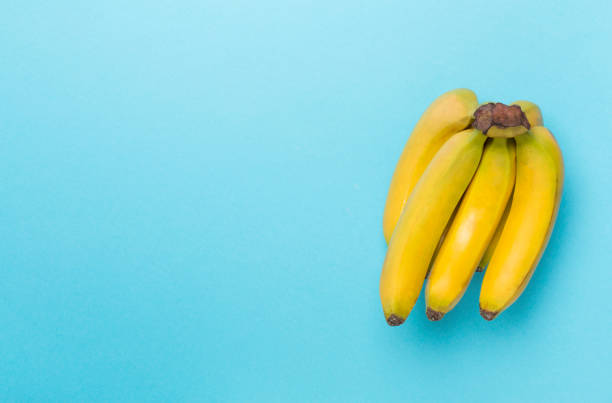 istock Fresh bananas on color background, top view 1704498044