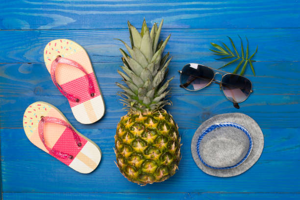 istock Creative pineapple hipster in sunglasses on wooden background, top view 1704498045
