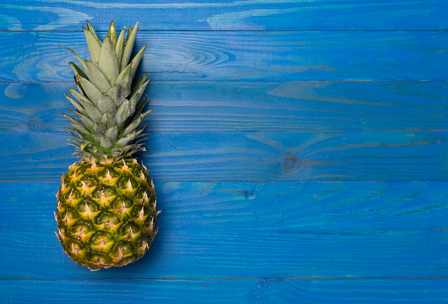 Fresh pineapple on wooden background, top view