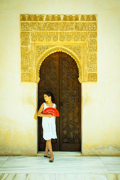 Spanish girl with red fan in the Alhambra Girl with red fan, resting by a beautiful door in the Alhambra, Granada (Spain). ancient creativity andalusia architecture stock pictures, royalty-free photos & images