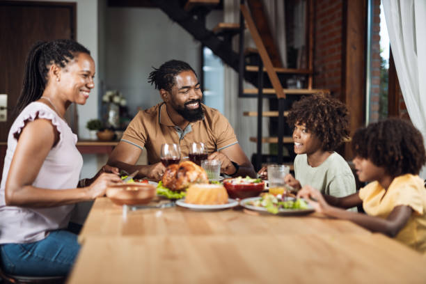 istock Happy black family talking while having lunch in dining room 1704512429