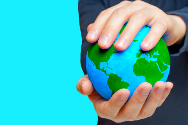 istock Man Protecting Green Globe Against a Blue Canvas 1704514590