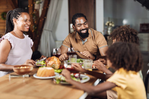 Happy black family talking while having lunch in dining room
