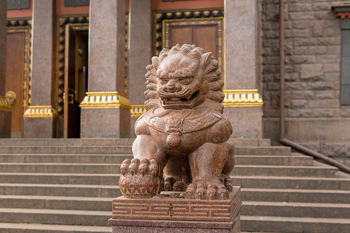 Saint Petersburg, Russia - August 01, 2023: stone statue of a lion at the entrance to the Buddhist Datsan Gunzechoinei