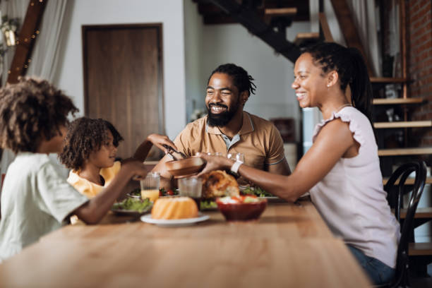 istock Young black family having Thanksgiving meal at dining table 1704519497