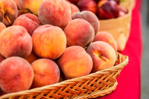 Ripe, juicy and fresh peaches in a basket  ready to be sold in a local farmers market