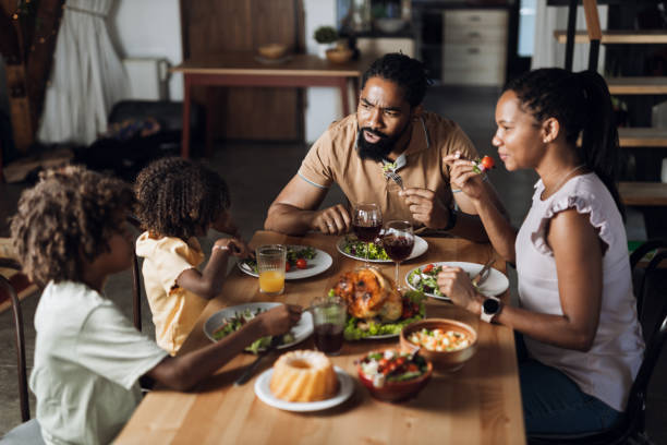 istock Young  black family talking while having lunch in dining room 1704530982