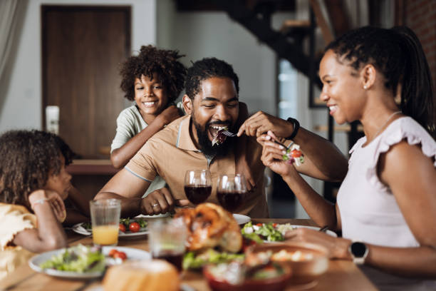 istock Young black family having dinner at dining table. 1704534620