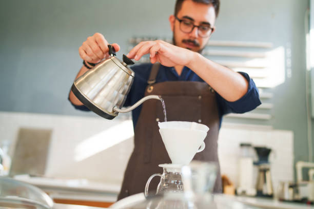 istock Barista brewing coffee behind the counter 1704544968
