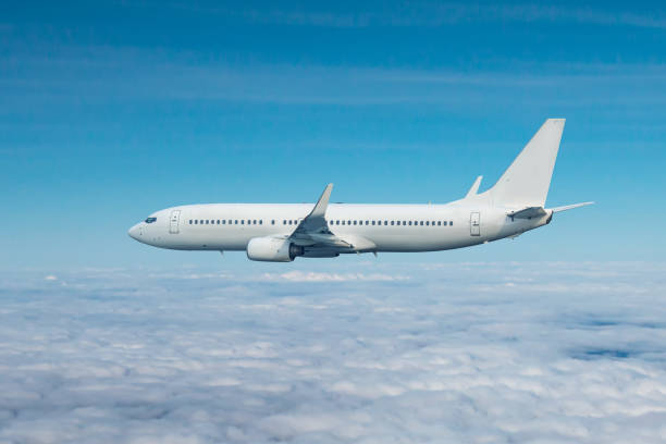istock White passenger airliner flying in the air above the clouds 1704545516