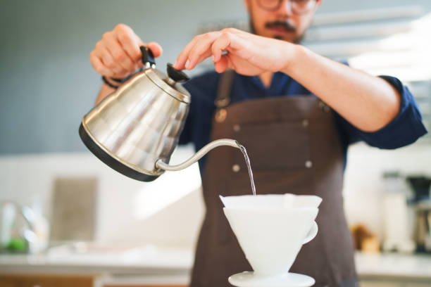 istock Barista brewing coffee behind the counter 1704546600