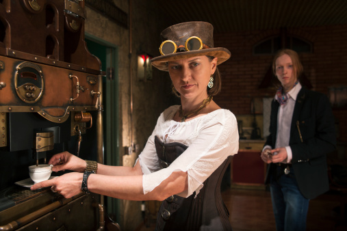 Young woman in steampunk stile make a coffee with coffee-macker machine
