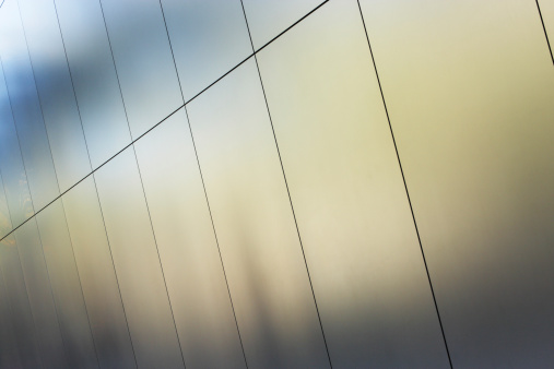Silver metallic building wall panels reflect a pattern and color in muted sunlight.  Phoenix, Arizona, 2013.